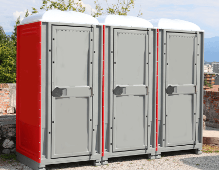 White and Red Color Portable Toilets Booths Installed in a Public Park